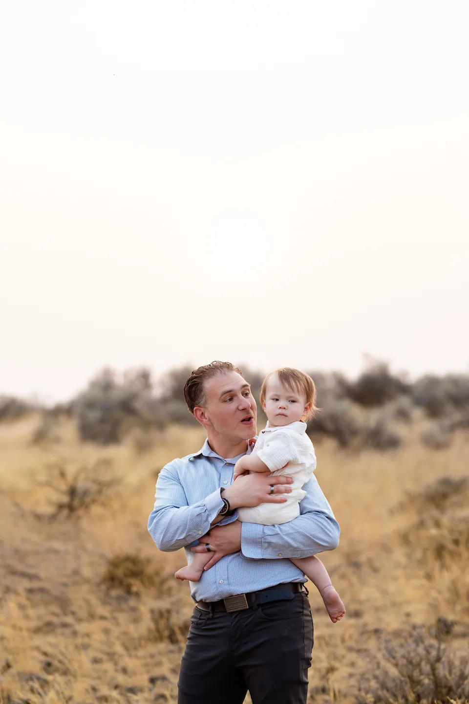 A baby held close during an outdoor family portrait session