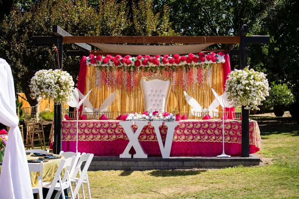 Floral quinceañera reception decorations with an XV display