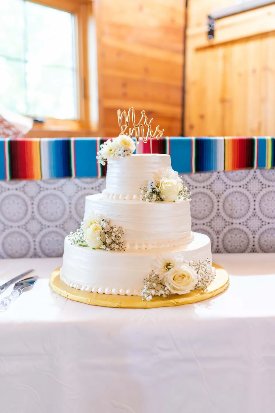 A tiered wedding cake decorated with white roses