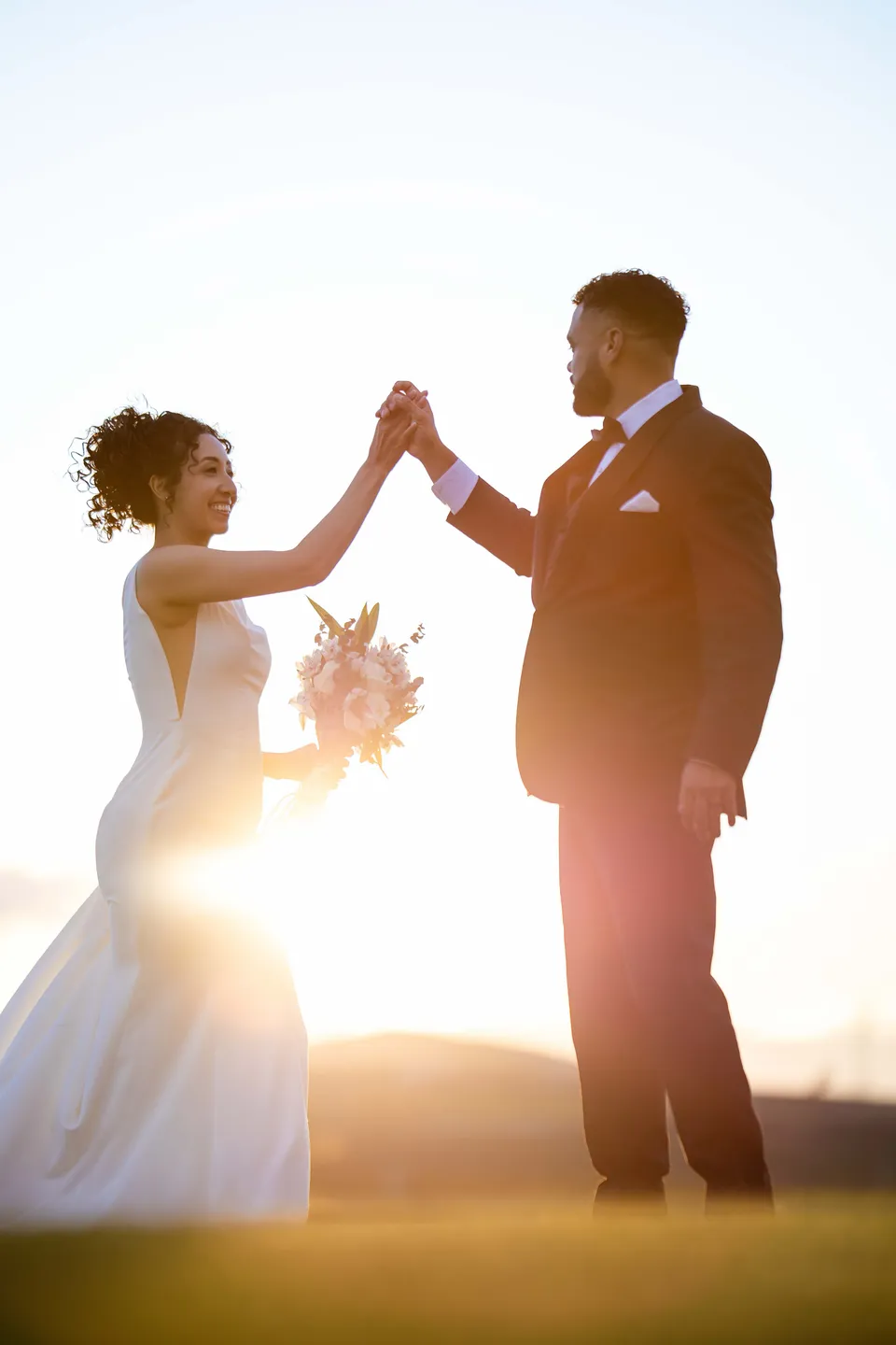 A couple holding hands in warm sunset light